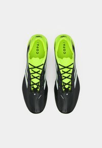 Pair of black and neon green Adidas Copa soccer shoes with black laces, viewed from above on a white background.