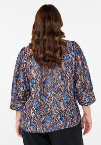 Blomstermønstret bluse med puffede ærmer, i nuancer af blå, brun og creme. Fremstillet af et blødt, struktureret stof.