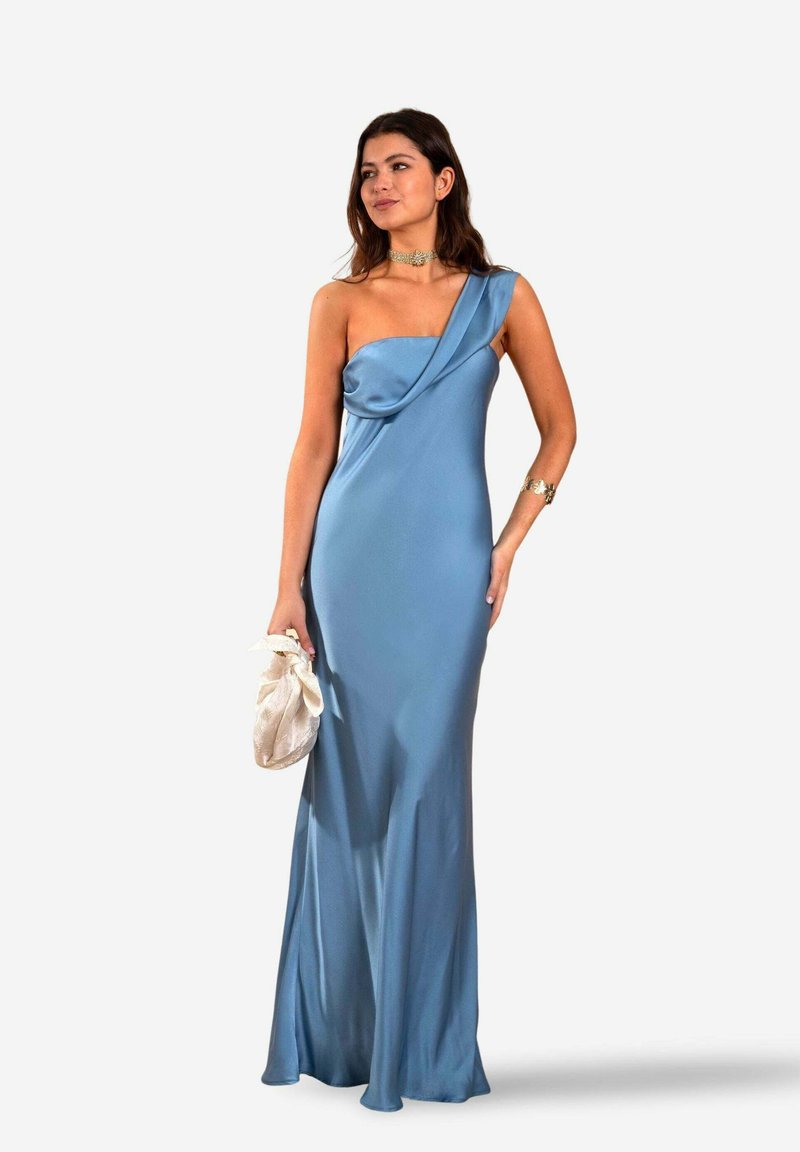 Himmelblaues Satin-Kleid mit einem Schulterdesign, drapierter Blende und fließendem Rock. Akzentuiert mit einem silbernen Armband und einer hellen Clutch.