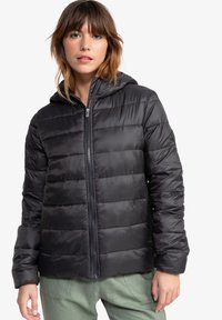 Veste rembourrée noire avec une capuche, dotée d'une fermeture éclair à l'avant, texture matelassée et poignets élastiques. Tissu lisse et léger, avec une silhouette ajustée.