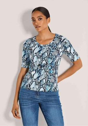 Korte mouwen top met een blauw en zwart slangenprintpatroon, ronde halslijn en een aansluitend design. Gecombineerd met blauwe denim jeans.