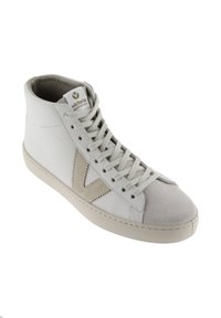 Zapatilla alta de cuero blanco con acentos de gamuza beige. Cuenta con suela de goma gris y cordones planos. Logo color marrón claro en la lengüeta.