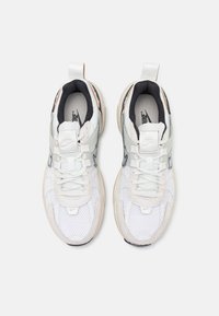 Sneaker in rete bianco e suede con dettagli neri, dotate di un tassello per il tallone testurizzato, colletto imbottito e molteplici occhielli per i lacci.
