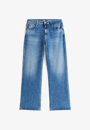 Sinised sirge säärega teksapüksid, millel on klassikaline viiepokotiline disain ja säärtel nähtavad pleegitused, asetatud tasapinnale valgel taustal.