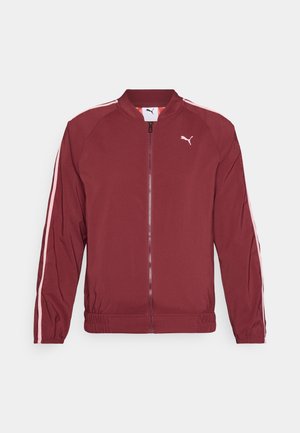 Burgundy tõmblukuga jakk, mis on valmistatud siledast kangast, valgete külgtriipudega ja ribatud äärisega. Kulub rinnapiirkonnas väike logo.