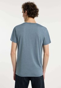 T-shirt à manches courtes en tissu bleu chiné, avec un col rond et une coupe décontractée, présentant des coutures droites et des détails minimalistes.