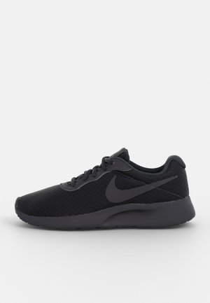 Czarny but do biegania Nike z cholewką z siateczki, wiązaniami i charakterystycznym logo Swoosh po boku, pokazany z profilu na białym tle.