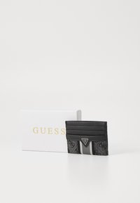 Porte-cartes avec un design noir et gris, surface texturée, plusieurs emplacements pour cartes et une plaque logo. Présenté dans une boîte de marque.