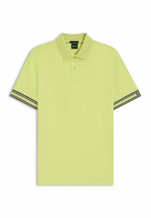 Koszulka polo z krótkim rękawem w jaskrawym limonkowym kolorze, z klasycznym kołnierzykiem, zapięciem na dwa guziki oraz czarno-białymi paskami na rękawach.