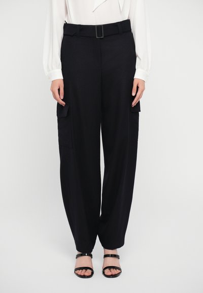 Pantalons cargo noirs avec une coupe large, comprenant deux poches latérales, une ceinture avec une boucle carrée et une texture de tissu lisse.