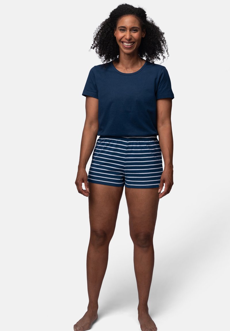 Marineblaue Baumwoll-T-Shirt mit kurzen Ärmeln, kombiniert mit blau-weiß gestreiften Shorts mit einem elastischen Bund.