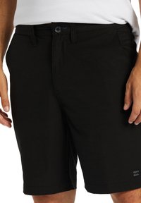 Pantaloni corti neri con un design elegante, realizzati in un tessuto misto cotone, dotati di chiusura con bottone, tasche laterali e dettaglio del logo sull'orlo.