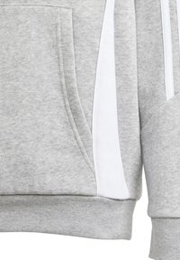 Grauer Sweatshirt mit weicher Textur, ausgestattet mit einer frontalen Tasche und weißen seitlichen Streifen. Beinhaltet gerippte Bündchen und Details am Saum.