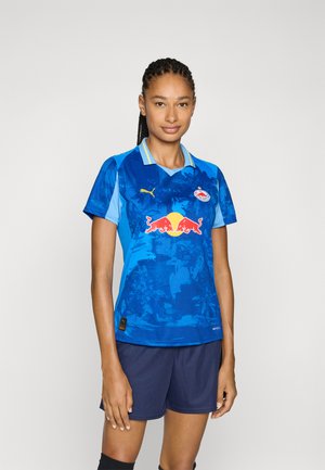 Plava nogometna majica kratkih rukava s kragnom i Red Bull logom na prednjoj strani. Sadrži gradient dizajn s kontrastnim svijetloplavim akcentima.