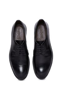 Chaussures habillées en cuir noir avec surface texturée, bout lisse et lacets fins. Inscrites avec "DERMOD" à l'intérieur de la chaussure. Design classique.