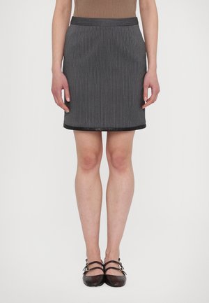 Harmaa pinstripe-minihame, jossa on sileä pinta ja musta helma sekä vyötärö. Yhdistetty tummanvärisiin, remmillisiin litteisiin kenkiin.