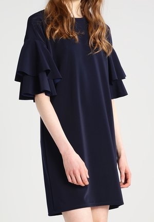 Robe bleu marine en tissu lisse, dotée de manches à volants superposés et d'une coupe décontractée. Ourlet court, sans motifs ni accents visibles.
