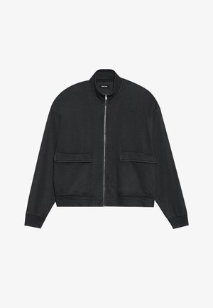 Fekete zipped dzseki magas gallérral, két elülső zsebbel, hosszú ujjakkal és laza szabással. Puha anyagból készült, sima textúrával.