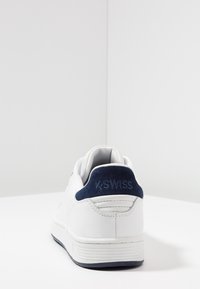 Bílé tenisky K-Swiss s námořnickou suédovou patou, hladkým koženým tělem a zaoblenou špičkou s minimálním detailem a texturovanou podrážkou.