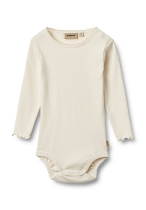 Body bébé à manches longues de couleur crème avec des bords festonnés, des fermetures à pression à l'entrejambe et aux épaules, étiquette de marque "Wheat" à l'intérieur du col.