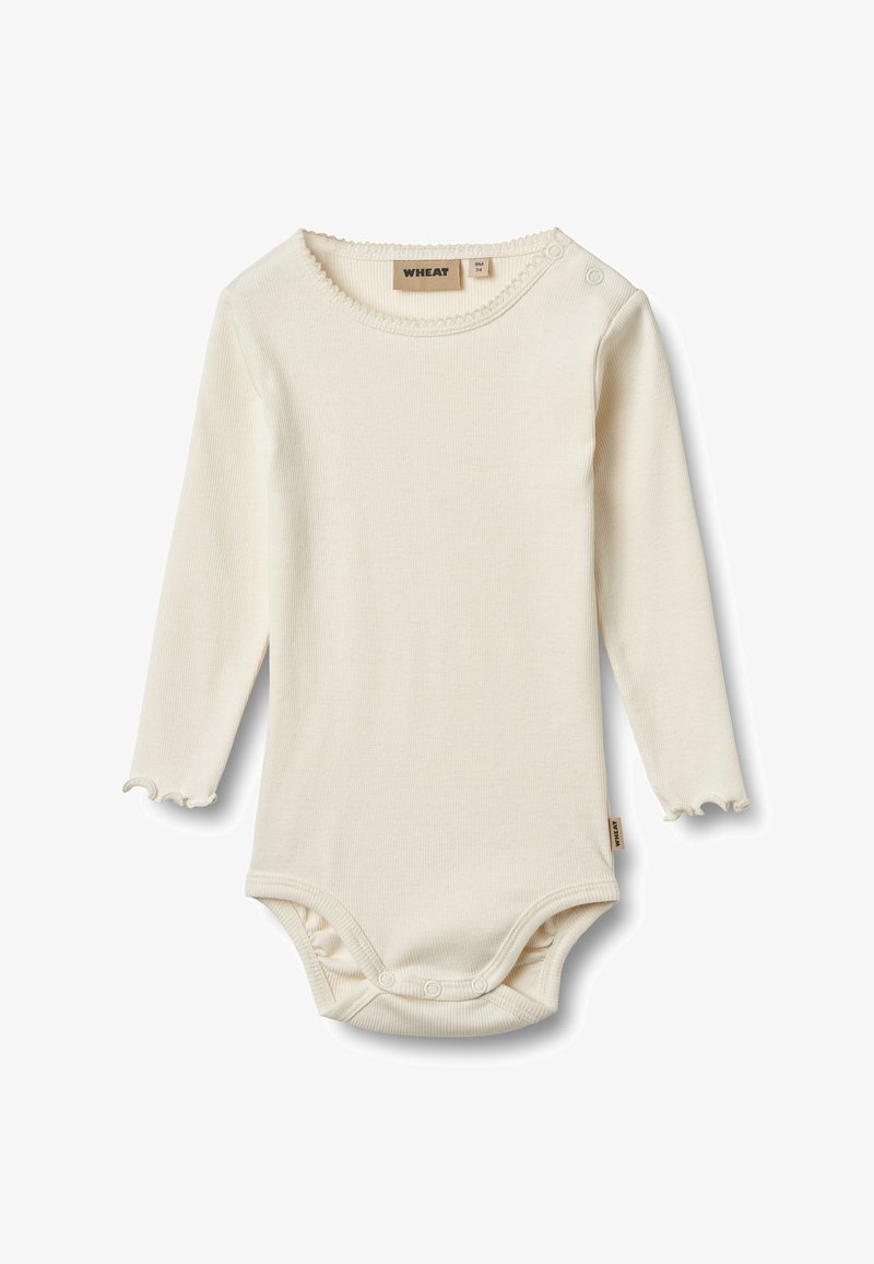 Body bébé à manches longues de couleur crème avec des bords festonnés, des fermetures à pression à l'entrejambe et aux épaules, étiquette de marque "Wheat" à l'intérieur du col.