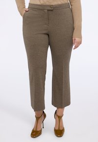 Brązowe spodnie w jodełkę z dopasowanym pasem, przednimi kieszeniami i prostym krojem nogawki, połączone z błyszczącymi brązowymi szpilkami.