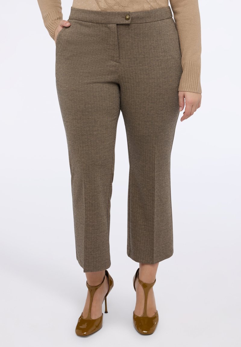 Brązowe spodnie w jodełkę z dopasowanym pasem, przednimi kieszeniami i prostym krojem nogawki, połączone z błyszczącymi brązowymi szpilkami.