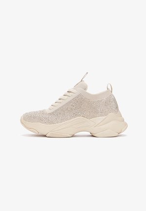 Beige sneakers with a textured knit upper featuring sparkling accents. Chunky sole with a layered design and a pull tab at the heel.
