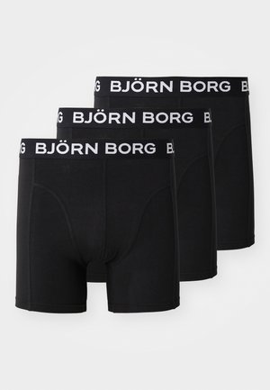 Melnas bokseru apakšbikses trīs iepakojumā, ar platu elastīgu jostasvietu, kurā ir balts "BJÖRN BORG" logo. Gluds audums, pieguļošs dizains.