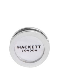 Hopeinen pyöreä kalvosinnappi, jossa on valkoinen sisustus ja mustat painetut tekstit "HACKETT LONDON". Sileä pinta ja kiillotetut reunat.