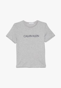 Grijze katoenen t-shirt met korte mouwen, met een marineblauw "CALVIN KLEIN" logo gecentreerd op de voorkant. Klassiek rondhalsontwerp.