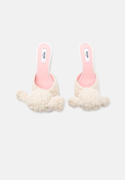 Paire d'escarpins crème duveteux à enfiler avec semelles intérieures roses et étiquettes de la marque Moschino visibles à l'intérieur.