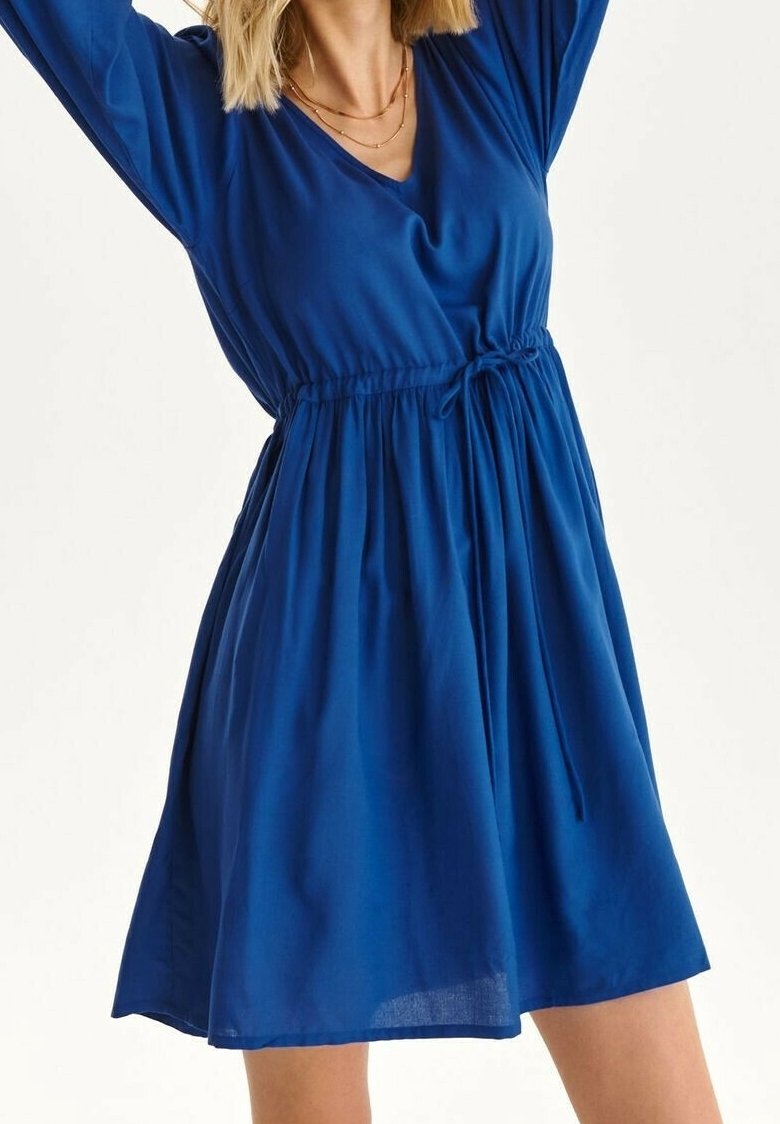 Sininen mekko, joka on valmistettu kevyestä kankaasta, jossa on V-pääntie, pitkät hihat, nyöritetty vyötärö ja A-linjainen siluetti.