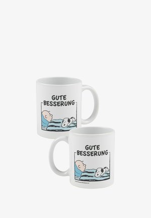 Weißer Keramikanhänger mit einem Design, das eine Figur im Bett mit einem Hund zeigt, sowie dem Text "GUTE BESSEERUNG" in fetten schwarzen Buchstaben.
