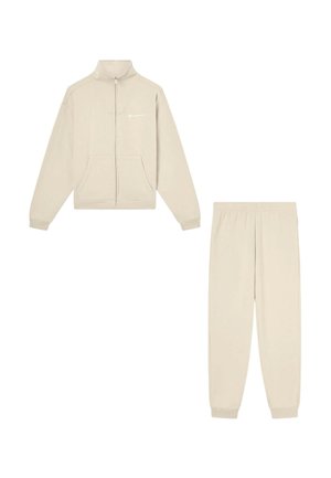 Felpa beige con zip integrale e tasche, abbinata a pantaloni jogger coordinati, entrambi realizzati in tessuto morbido per un abbigliamento casual.