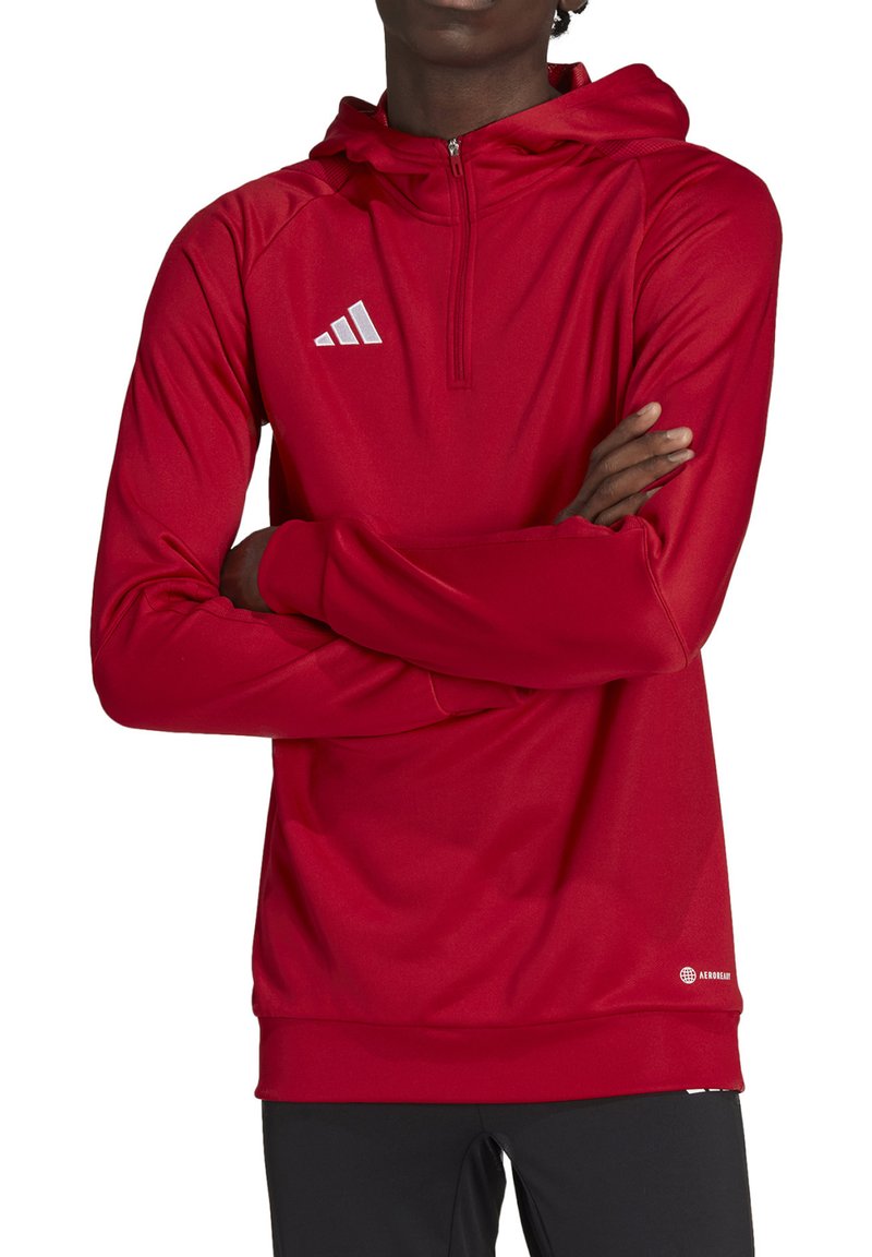 Felpa sportiva rossa con zip sul collo, maniche lunghe e finitura testurizzata. Presenta il logo Adidas bianco sul petto e orlo a coste.