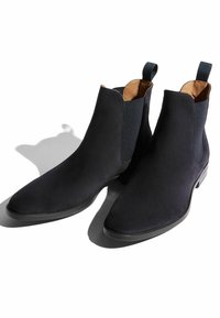 Schwarze Wildleder-Ankle-Chelsea-Boots mit elastischen Seitenpaneelen, spitzer Zehenpartie und glatter Sohle. Mit Ziehlaschen hinten für ein einfaches Anziehen.