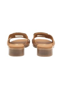 Las sandalias de cuero marrón presentan un diseño de punta abierta, suela plana y una hebilla sencilla. Plantilla texturada y tacón rectangular bajo.