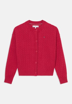 Czerwony sweter zapinany na guziki, pleciony w wzór w warkocze, z okrągłym dekoltem i ściągaczami na mankietach. Guziki z przodu w pasującym kolorze z małym akcentem logo na klatce piersiowej.