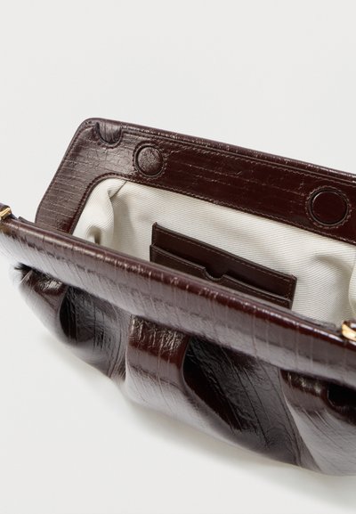 Σκούρο καφέ τσάντα από δέρμα με υφή, ανοιχτή για να φαίνεται η επένδυση από λευκό ύφασμα και εσωτερική θήκη για κάρτες με μαγνητικό κλείσιμο.