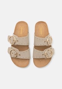 Sandali a scivolo beige con due ampie cinghie dotate di fibbie dorate e borchie decorative. La soletta è realizzata in materiale di sughero texture.