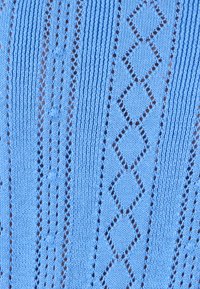 Tejido de punto azul claro con rayas verticales, patrones de diamantes y detalles de calado con ojetes espaciados de manera uniforme a lo largo.