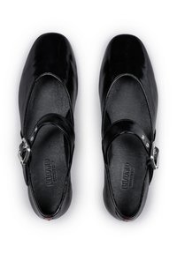 Chaussures Mary Jane en cuir noir avec une finition brillante, bout rond et une sangle à boucle unique à la cheville. Doublure intérieure texturée.