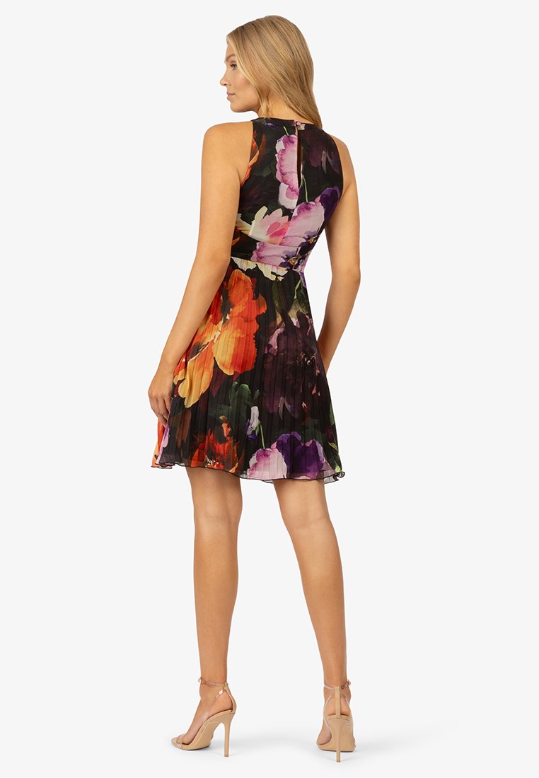 Vestido sin mangas con estampado floral, con un corpiño ajustado y falda plisada. Flores coloridas en rojo, púrpura y naranja sobre un fondo negro.