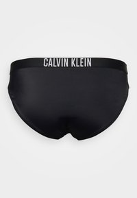 Os boxers pretos da Calvin Klein apresentam um tecido suave, um design ajustado e uma faixa elástica preta com "CALVIN KLEIN" em letras brancas.