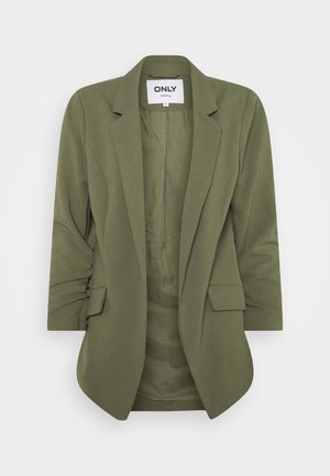 Oliwkowa marynarka damska z wciętymi klapami, dwoma kieszeniami z patką i rękawami do połowy przedramienia, oznaczona metką "ONLY tailoring".