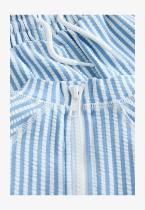 Gaiši zils svītrains audums ar rāvējslēdzēju un regulējamu baltu aukliņu. Faktūra ir ribota ar mainīgām plānām un biezām svītrām.