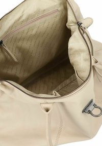 Borsa a mano in pelle beige con una trama morbida, dotata di chiusura con zip e fodera interna che riporta la scritta "HARBOUR 12 ND" in un leggero motivo ripetuto.