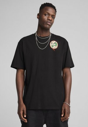 Czarna bawełniana koszulka z okrągłą zieloną i czerwoną grafiką na klatce piersiowej; luźny krój z krótkimi rękawami i gładką teksturą.