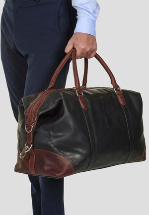 Black leather duffel bag with brown leather accents, featuring double handles, a zipper closure, and metal hardware details.